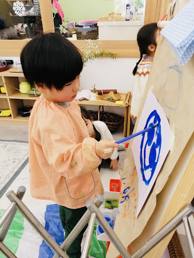 A child paints at the easel which is the perfect opportunity to express their creativity without adult influence.