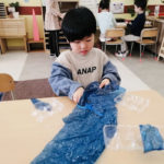 A child explores using recycled materials to make an “ocean like in Okinawa”, which was how they described their work.